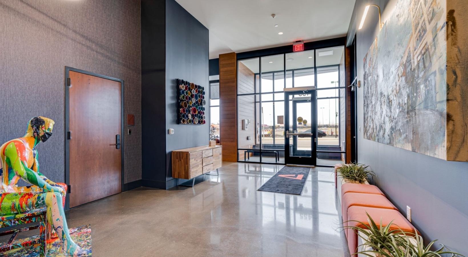 Everything within reach a room with a large glass door and a large glass wall with art on it
