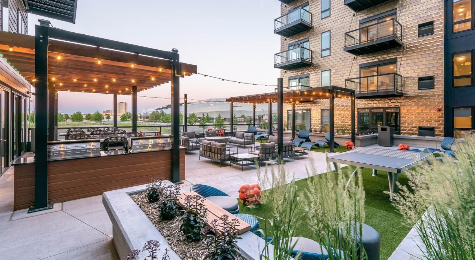 Enjoy our resident-only features a courtyard with tables and chairs and plants in front of a building